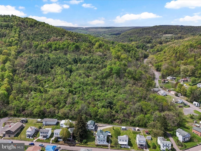 drone / aerial view featuring a residential view and a forest view
