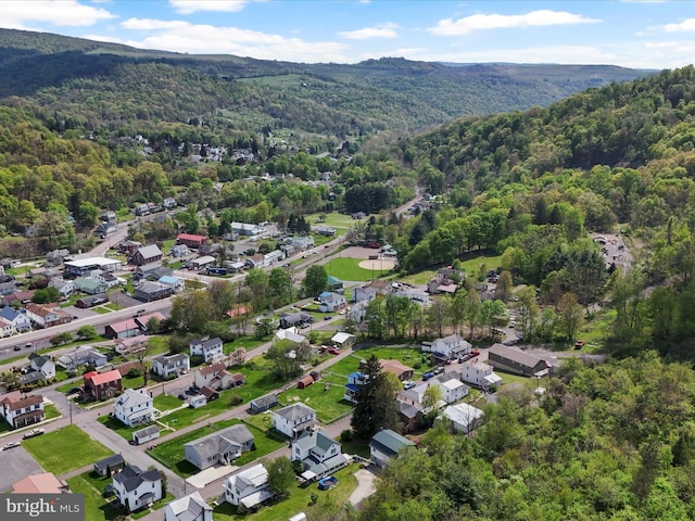 aerial view featuring a forest view, a residential view, and a mountain view