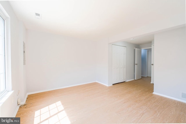 unfurnished room featuring baseboards, visible vents, and light wood-type flooring