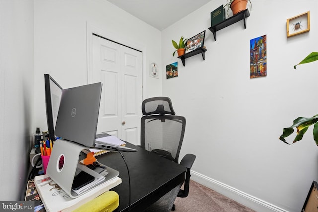 carpeted office featuring baseboards
