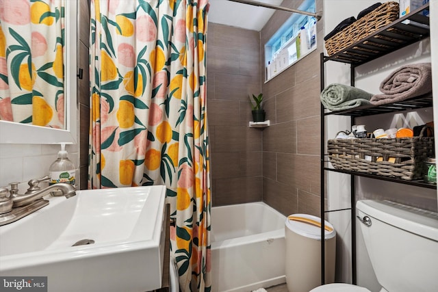 bathroom featuring shower / tub combo with curtain, a sink, tasteful backsplash, and toilet