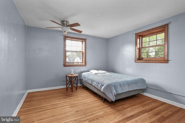 bedroom featuring light wood-style flooring, baseboards, and ceiling fan