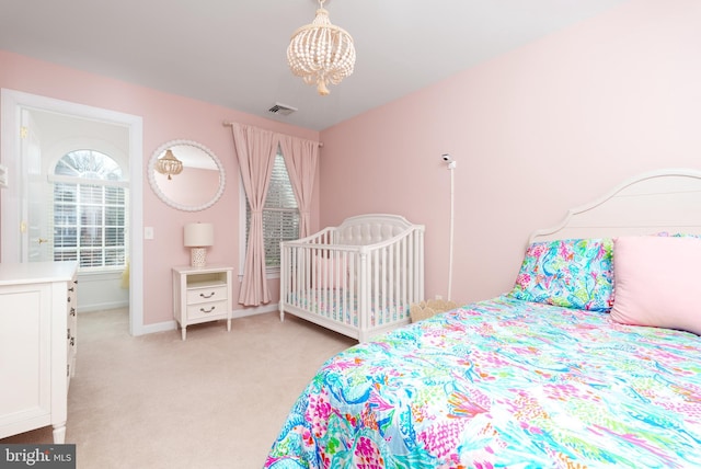 bedroom featuring a chandelier, light colored carpet, and baseboards