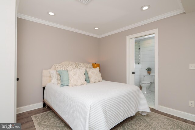 bedroom featuring wood finished floors, baseboards, crown molding, recessed lighting, and ensuite bath