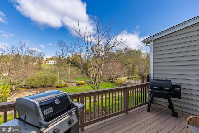 wooden terrace with a grill and a lawn