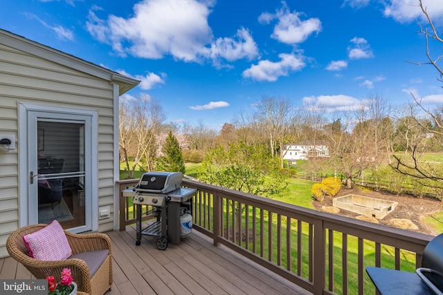 wooden terrace featuring area for grilling and a yard