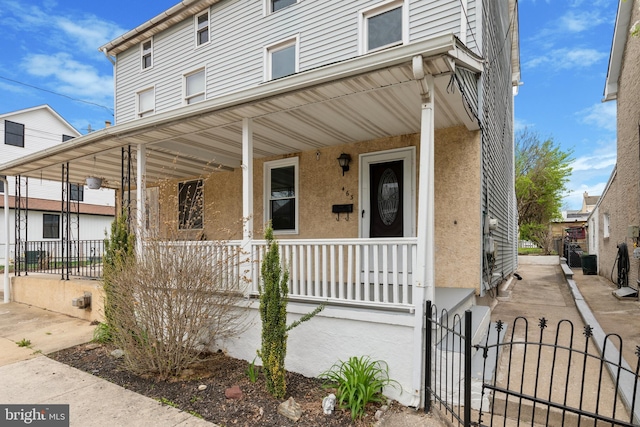 463 New Elm St, Conshohocken, PA 19428 - view of front of property with a porch, a gate, a fenced front yard, and stucco siding