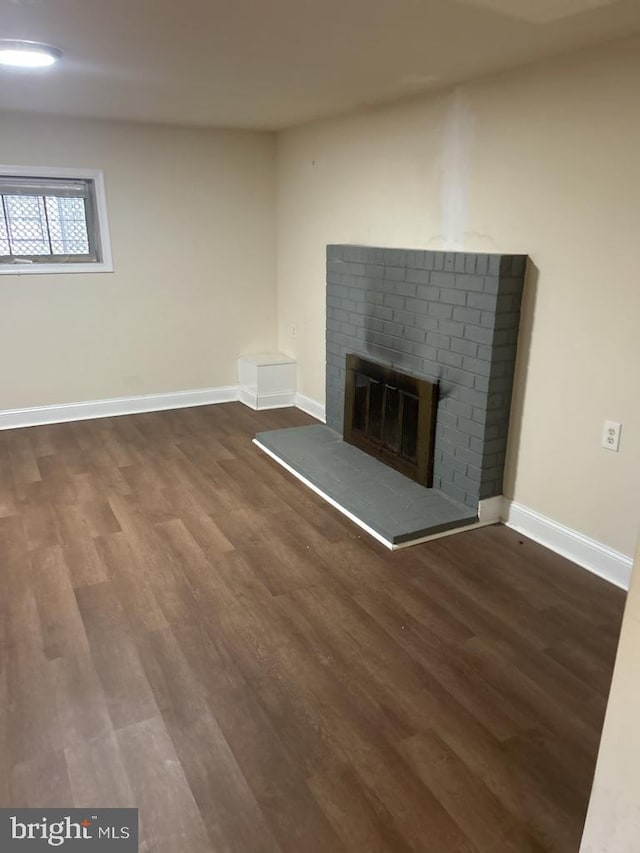 419 Larchmont Ave, Capitol Heights, MD 20743 - unfurnished living room with baseboards, a brick fireplace, and wood finished floors