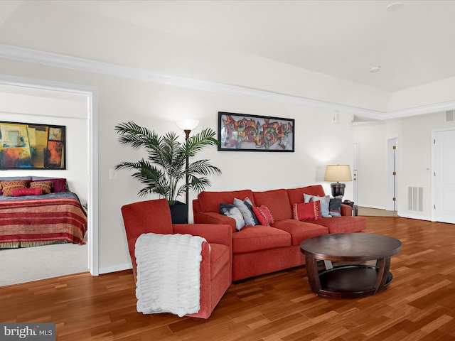 living area featuring visible vents and wood finished floors