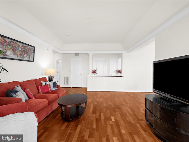 living area featuring visible vents, a raised ceiling, and wood finished floors