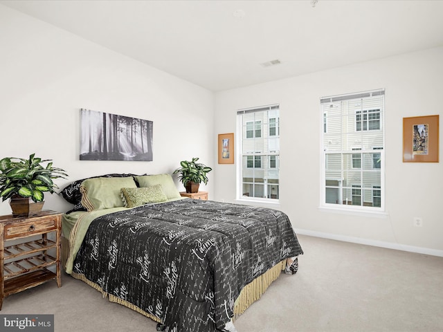 carpeted bedroom featuring baseboards and visible vents