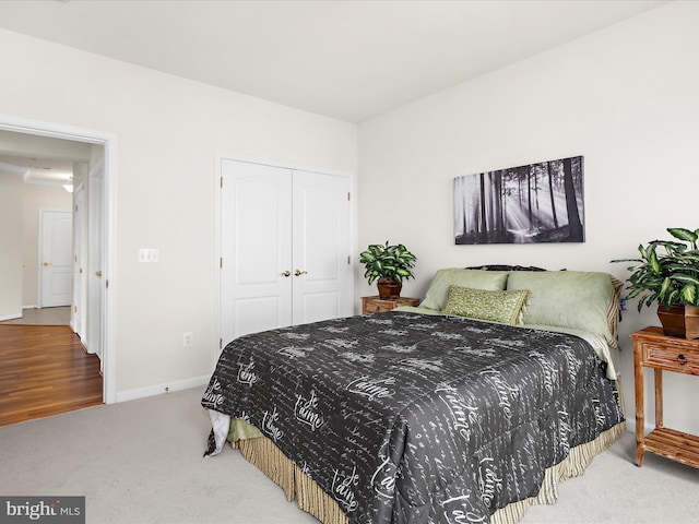 carpeted bedroom with baseboards and a closet