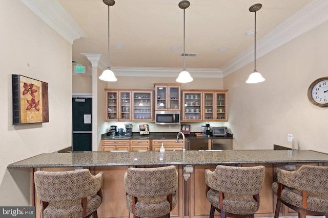kitchen with visible vents, crown molding, hanging light fixtures, stainless steel microwave, and a peninsula