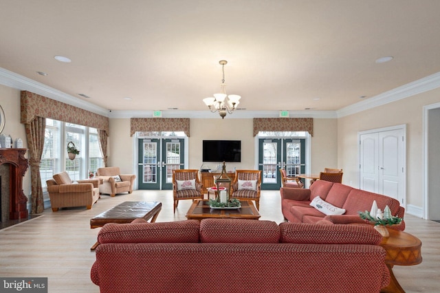 living room featuring ornamental molding, french doors, light wood finished floors, and a chandelier