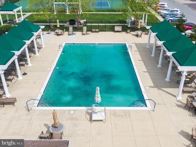 community pool featuring a patio area and fence