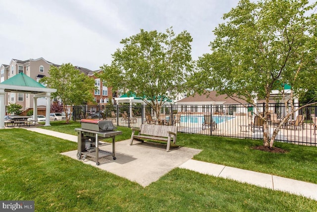 surrounding community with a lawn, a swimming pool, and fence