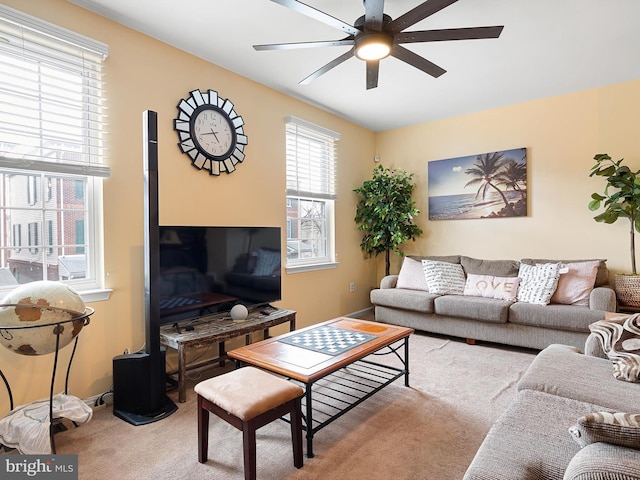 carpeted living area with ceiling fan
