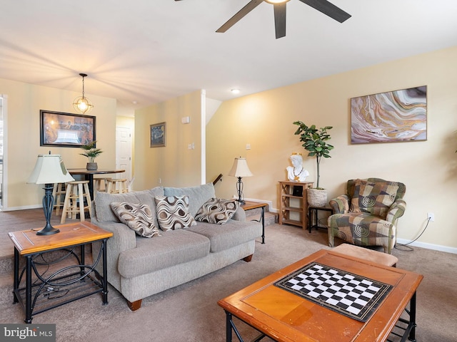 living room featuring carpet floors, baseboards, and ceiling fan