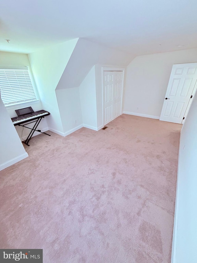 additional living space featuring vaulted ceiling, carpet flooring, and baseboards