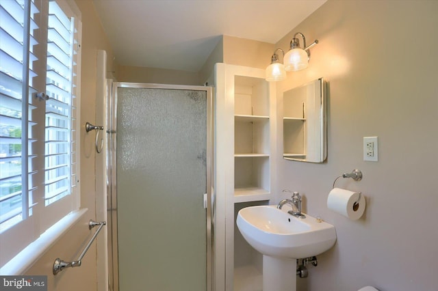 full bath featuring a shower stall, a healthy amount of sunlight, and a sink