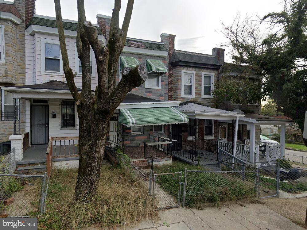 multi unit property with a porch, a gate, stone siding, and a fenced front yard
