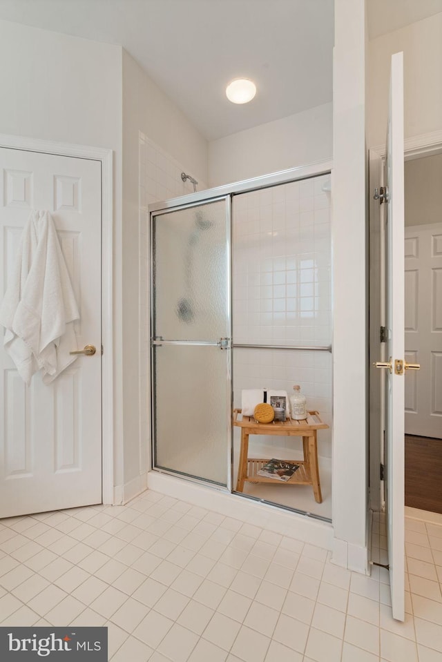 full bath with tile patterned flooring and a shower stall