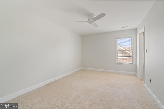 unfurnished room featuring baseboards, visible vents, a ceiling fan, and light colored carpet