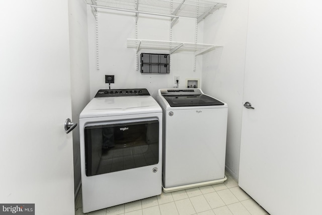 laundry area featuring washer and clothes dryer and light tile patterned flooring