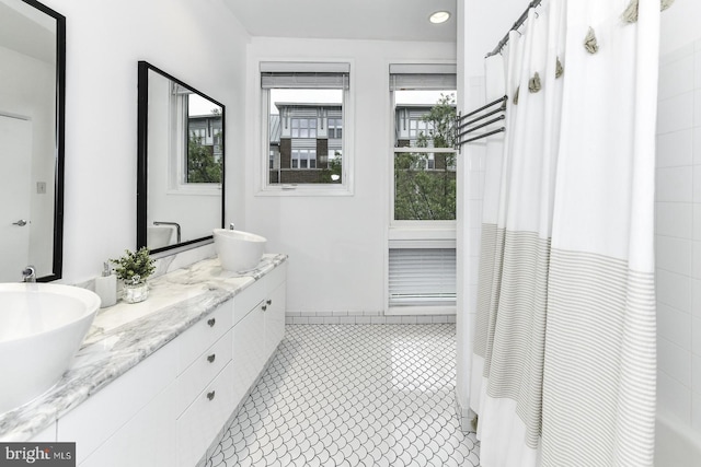 full bathroom with a shower with shower curtain, double vanity, and tile patterned flooring