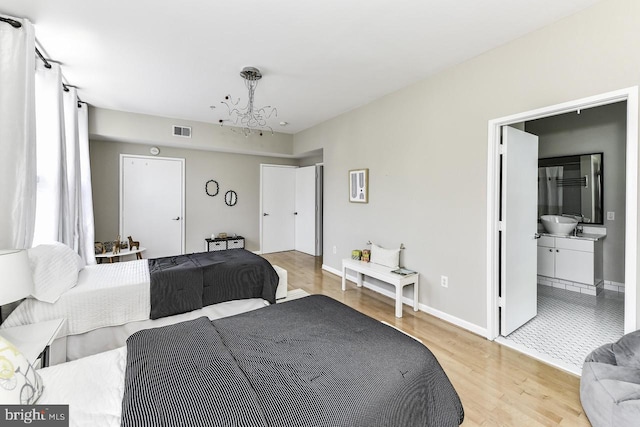 1688 N Quinn St, Arlington, VA 22209 - bedroom with light wood-style flooring, a chandelier, and connected bathroom