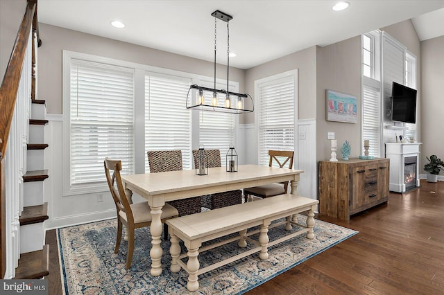 dining space featuring a decorative wall, wainscoting, a notable chandelier, dark wood-style floors, and recessed lighting