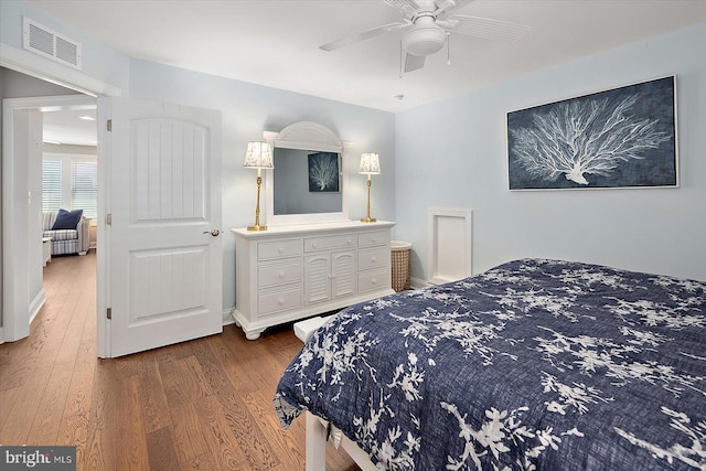 bedroom featuring wood finished floors, visible vents, and a ceiling fan