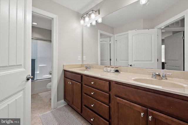 full bath with toilet, a sink, double vanity, and combined bath / shower with glass door