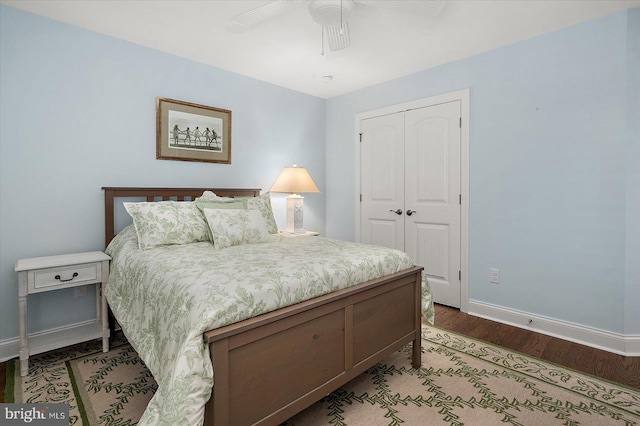 bedroom with wood finished floors, a closet, a ceiling fan, and baseboards