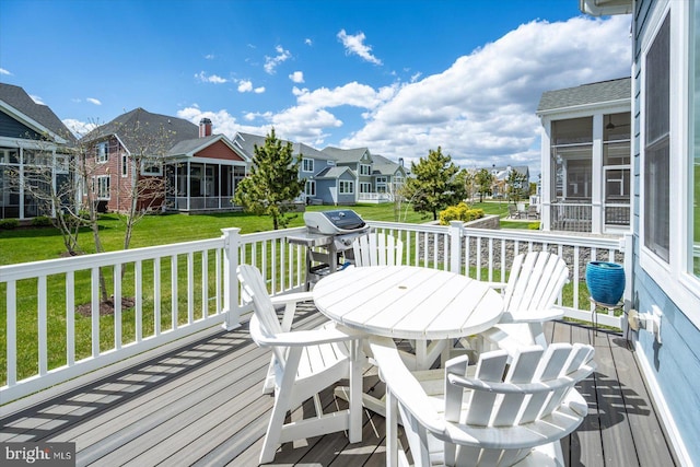 wooden deck with a yard, a sunroom, and a residential view