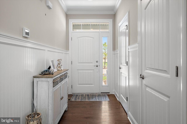 foyer entrance with a decorative wall, crown molding, dark wood-style flooring, and wainscoting