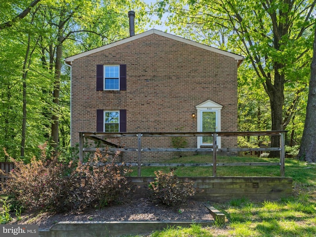 view of property exterior featuring brick siding and fence