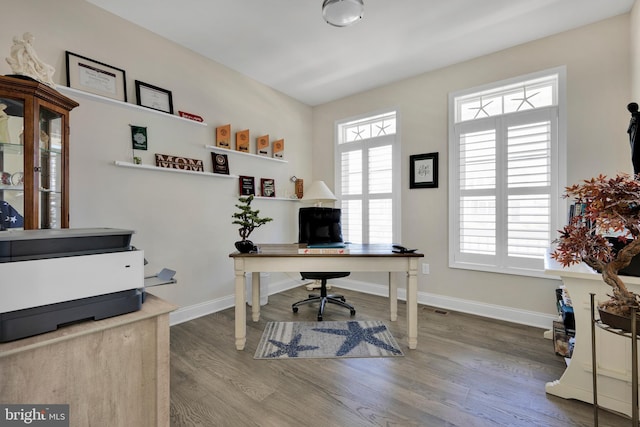 office with baseboards, wood finished floors, and visible vents