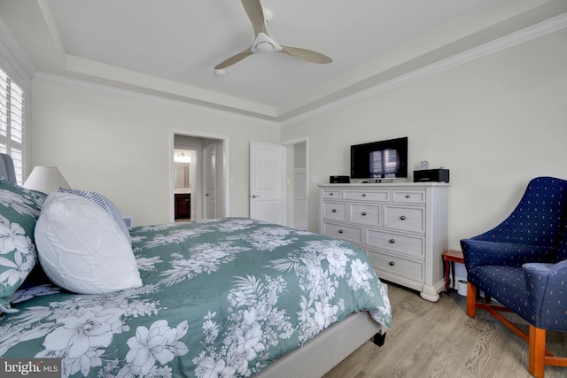 bedroom featuring crown molding, a ceiling fan, a tray ceiling, and light wood finished floors