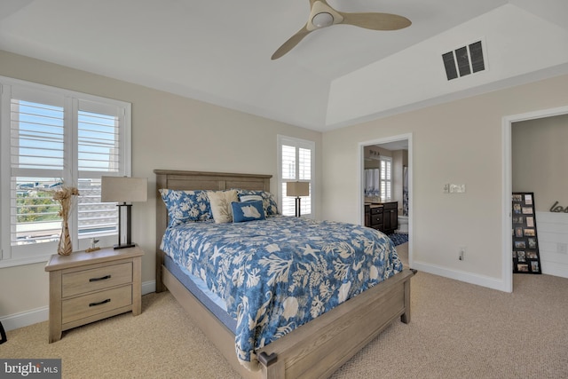 bedroom with a ceiling fan, visible vents, light colored carpet, baseboards, and connected bathroom