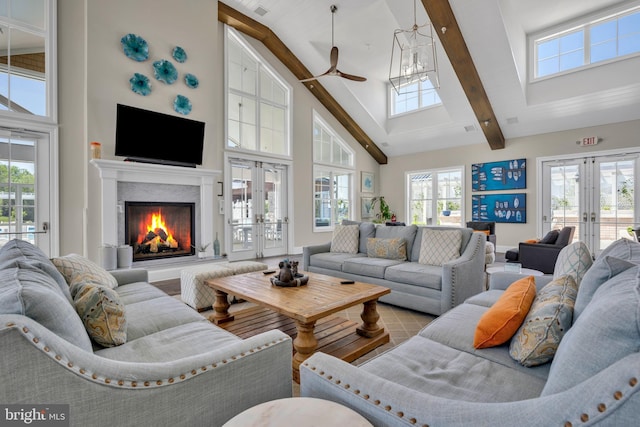 living area featuring high vaulted ceiling, a ceiling fan, french doors, and a premium fireplace