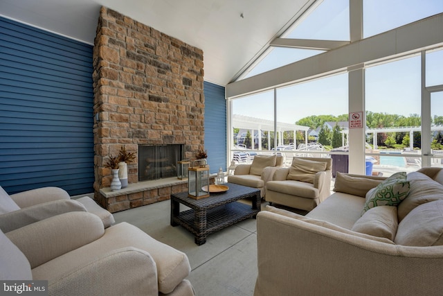 living room with a healthy amount of sunlight, high vaulted ceiling, and a fireplace