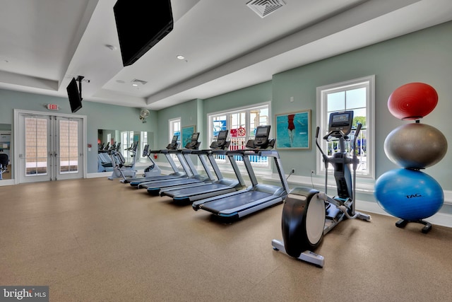 gym with baseboards, french doors, a raised ceiling, and visible vents