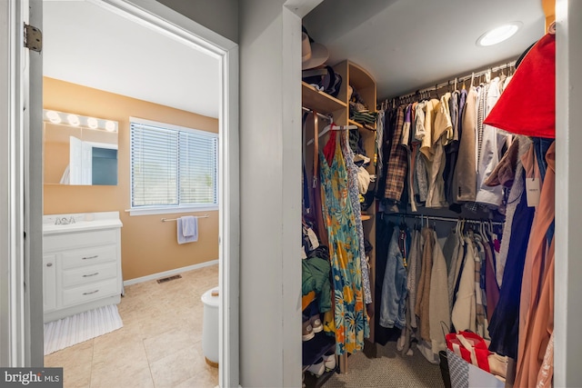 spacious closet featuring tile patterned flooring, a sink, and visible vents