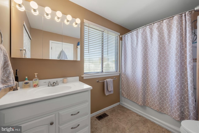 bathroom featuring visible vents, toilet, vanity, shower / bath combo with shower curtain, and baseboards