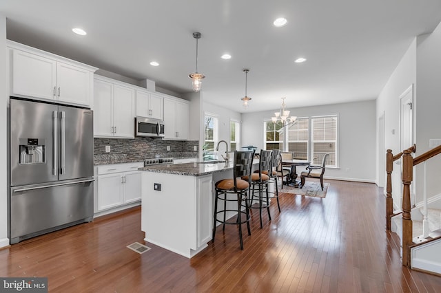 625 E G St, Purcellville, VA 20132 - kitchen featuring a sink, a breakfast bar, a kitchen island with sink, stainless steel appliances, and white cabinets
