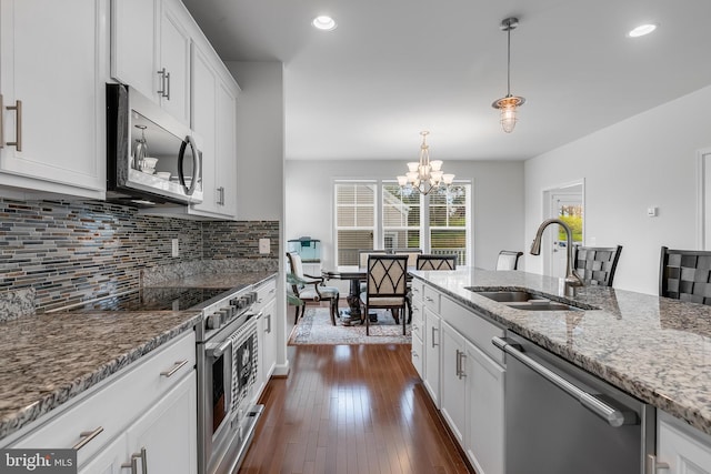 625 E G St, Purcellville, VA 20132 - kitchen with light stone counters, stainless steel appliances, a sink, a chandelier, and tasteful backsplash