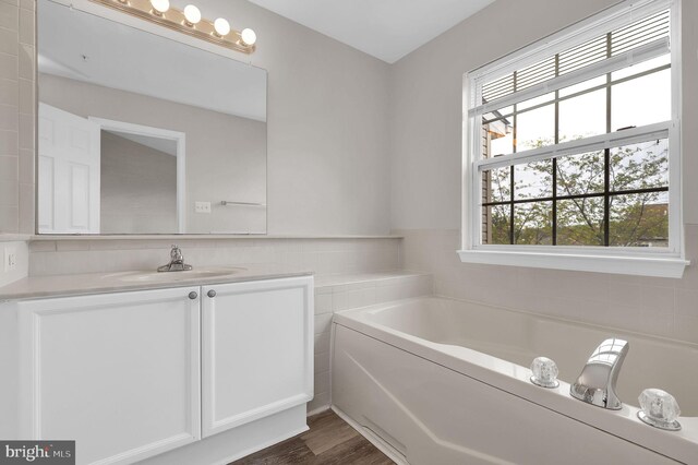 2475 Lakeside Dr, Frederick, MD 21702 - full bathroom with a bath, vanity, wood finished floors, and tile walls