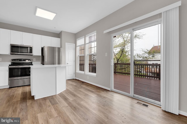 2475 Lakeside Dr, Frederick, MD 21702 - kitchen with light countertops, light wood-style flooring, white cabinets, appliances with stainless steel finishes, and visible vents