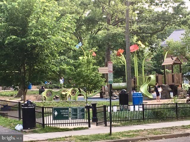 view of community featuring fence and playground community